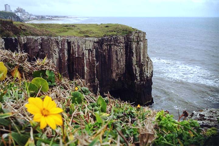 Essas formações basálticas, conhecidas como “torres de pedra”, deram origem ao nome do município e compõem uma paisagem rara no Brasil. Em frente à costa, destaca-se ainda a Ilha dos Lobos, a única ilha marítima do estado do Rio Grande do Sul, que abriga rica biodiversidade e é importante refúgio de animais marinhos. Somam-se a esse conjunto ainda parques naturais, lagoas e áreas de Mata Atlântica, compondo um território que alia beleza cênica, relevância ambiental e forte apelo turístico.

