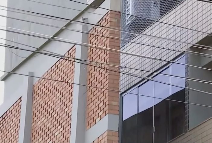 Muro gigante que bloqueia visão de condomínio residencial para quintal de casa em Passos (MG); estrutura existe desde 2001 - Reprodução/EPTV