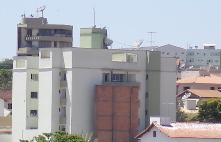 Muro gigante que bloqueia visão de condomínio residencial para quintal de casa em Passos (MG); estrutura existe desde 2001 - Reprodução/Record