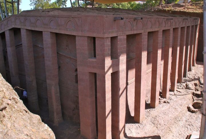 Cada detalhe, desde as janelas em formato de cruz até os pilares internos, surge de uma única peça de pedra maciça. A igreja de Bete Medhane Alem se destaca como a maior igreja monolítica do mundo, cercada por colunas que sustentam sua imponência. 