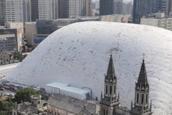 Obras de construção civil passaram a adotar enormes coberturas infláveis em formato de domo em grandes centros urbanos da China. O objetivo é reduzir os impactos ambientais causados pelos canteiros.  -  (crédito: Reproduc?a?o/YouTube)