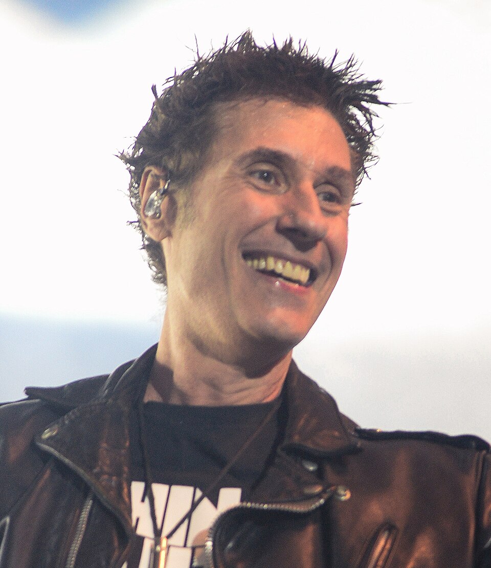 Aos 11 anos, teve os primeiros contatos com o rock por meio de Herbert Vianna e Bi Ribeiro, que mais tarde fundariam a banda Os Paralamas do Sucesso. Passou um período fora do Brasil e retornou aos 16 anos, quando a cena punk começava a ganhar força nas ruas de Brasília. Nessa época, passou a frequentar encontros da chamada Turma da Colina, um ponto estratégico de onde se podia observar toda a cidade.
