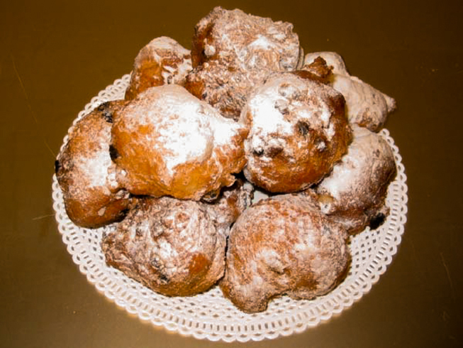 Os oliebollen são bolinhos fritos semelhantes a donuts, tradicionalmente consumidos na virada do ano. Recheados com passas ou maçã, são polvilhados com açúcar de confeiteiro e simbolizam prosperidade. Essa tradição mostra como a gastronomia acompanha os rituais festivos e reforça laços comunitários.