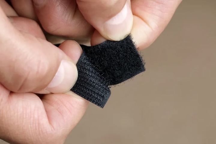 Após anos de experimentação com diferentes materiais, ele patenteou em 1955 um sistema de fechamento composto por duas fitas de nylon: uma com ganchos rígidos e outra com laços flexíveis. O nome da invenção nasceu da combinação das palavras francesas velours (veludo) e crochet (gancho).