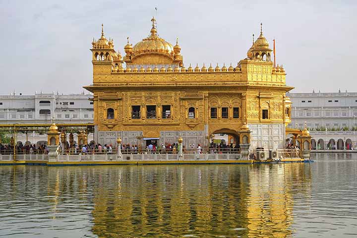 O Templo Dourado, ou Harmandir Sahib, é o centro espiritual mais importante do sikhismo. Fica em Amritsar, na Índia. Sua estrutura coberta de ouro e rodeada por um lago sagrado atrai milhões de visitantes todos os anos, tanto fiéis quanto turistas. O templo simboliza  igualdade, humildade e serviço comunitário, valores centrais da fé sikh. Fora o espaço de oração, é também um local de acolhimento, onde todos são recebidos sem distinção de religião, casta ou origem, além de ser o maior refeitório -  (crédito: Shagil Muzhappilangad/Wikimédia Commons)
