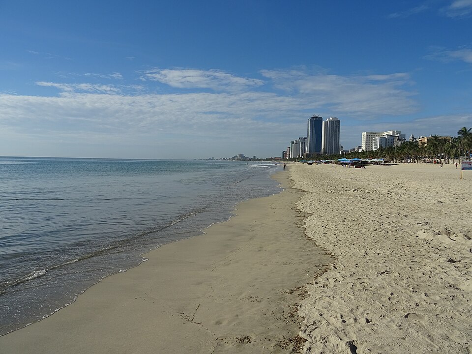 My Khe Beach, em Da Nang, é famosa por sua areia clara e águas mornas que atraem tanto famílias quanto surfistas. A praia combina tranquilidade com esportes aquáticos, oferecendo opções para diferentes perfis de viajantes. Além disso, sua proximidade com a cidade garante acesso fácil a restaurantes e infraestrutura turística, conectando lazer costeiro à vida urbana. My Khe também é reconhecida por competições de surfe e pela vigilância costeira eficiente, reforçando sua reputação como destino se