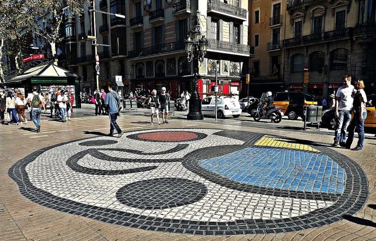 Ao caminhar pelo seu calçadão central, o visitante encontra bancas de flores tradicionais que perfumam o ar, enquanto artistas de rua e estátuas vivas capturam o olhar dos passantes curiosos. O famoso mosaico de Joan Miró, incrustado no próprio solo por onde milhares de pessoas transitam diariamente, é um convite a uma pausa breve para contemplação da arte moderna.