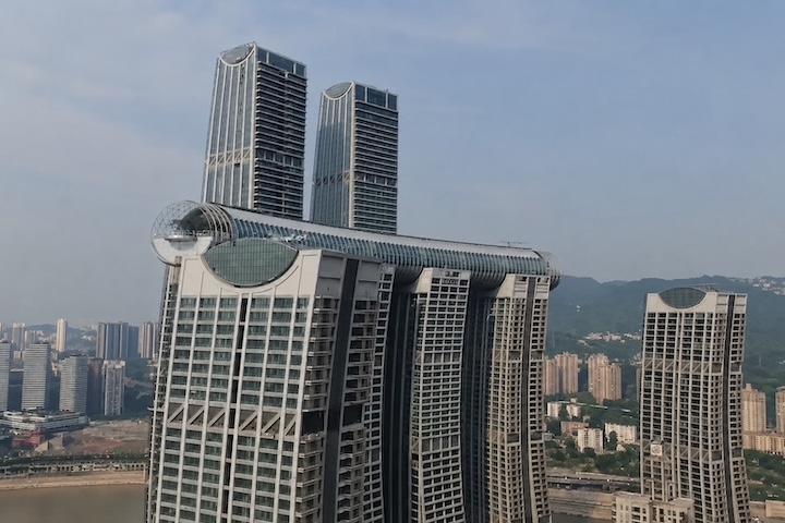 Em vez de descarregar todo o peso diretamente no solo, o The Crystal transfere a carga para quatro torres elevadas a centenas de metros de altura. Cada edifício precisou receber fundações e pilares reforçados para suportar não apenas a própria massa, mas também o enorme bloco suspenso entre eles. O desafio técnico ganhou ainda mais complexidade por causa dos ventos fortes e tempestades frequentes da região, exigindo cálculos estruturais extremamente precisos para garantir estabilidade e seguranç