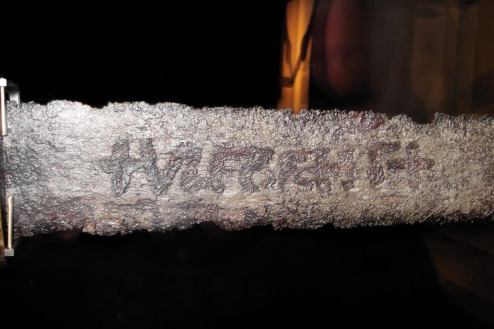 O elemento mais misterioso dessas espadas é a inscrição “+VLFBERH+T”, gravada diretamente nas lâminas. Até hoje não existe consenso sobre o significado exato do nome. Alguns pesquisadores acreditam que ele identificava um artesão extremamente respeitado, enquanto outros defendem que a inscrição funcionava como uma espécie de selo usado por oficinas especializadas em armas de alta qualidade. Há ainda hipóteses que apontam para uma tradição familiar mantida durante várias gerações.
