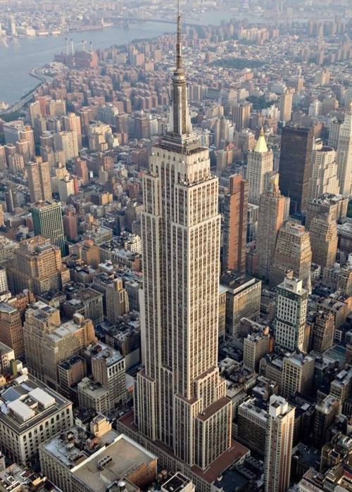 O Empire State Building foi inaugurado em 1º de maio de 1931, em plena Grande Depressão, e rapidamente se tornou símbolo da resiliência e da ambição norte-americana. Com 102 andares e 381 metros de altura (443 metros incluindo a antena), foi o edifício mais alto do mundo por quase quatro décadas, até a construção das Torres Gêmeas em Nova York. Sua arquitetura art déco e sua imponência transformaram-no em ícone cultural, aparecendo em filmes, livros e fotografias que marcaram gerações. O edifíci -  (crédito: domínio público)