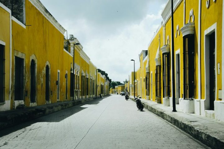 A presença dominante da cor não surgiu por causa de uma única decisão oficial, mas sim de um processo histórico gradual. Desde o período colonial, tons amarelados já apareciam nas construções locais devido ao uso de cal e pigmentos minerais adequados ao clima quente do sul mexicano. Com o passar do tempo, a padronização ganhou força no centro urbano e tornou-se ainda mais evidente após a visita do papa João Paulo II, em 1993.
