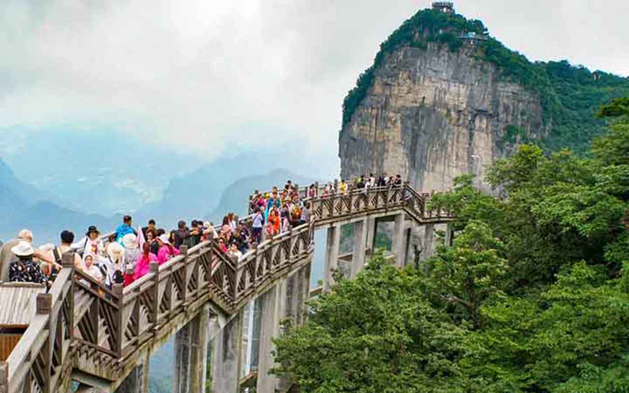 Explorar Zhangjiajie a pé é uma aventura inesquecível. Trilhas levam a miradouros suspensos, onde a vista das montanhas é de tirar o fôlego. Cada percurso revela novas perspectivas, reforçando a sensação de estar em um mundo fantástico, como se fosse Pandora.