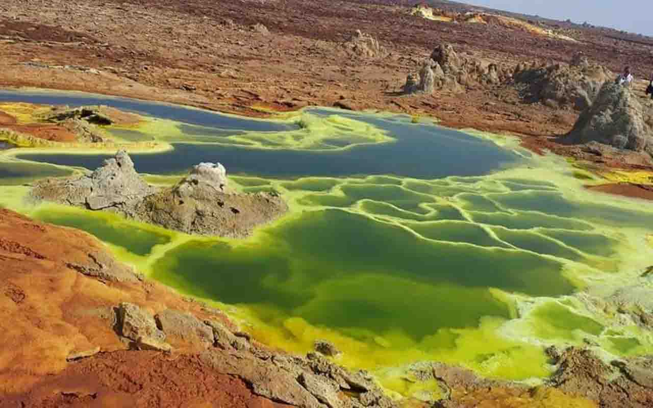 As águas ácidas e os minerais oxidam-se em contato com o ar, tingindo o solo em cores vibrantes: verdes, laranjas, vermelhos e ocres. Estruturas em forma de cogumelos e flores de sal surgem e desaparecem rapidamente, tornando o Dallol um espetáculo de arte natural em constante transformação.