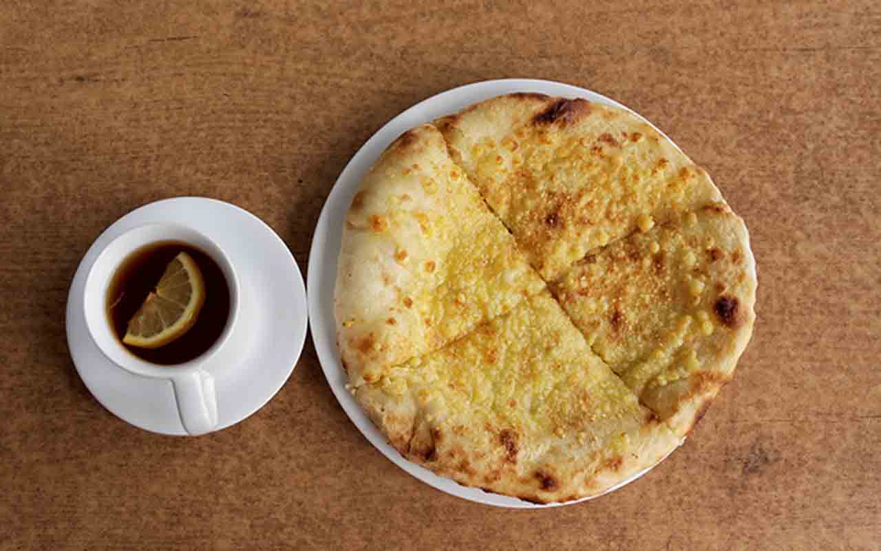 Na gastronomia, destaca-se o khachapuri, um pão macio recheado com queijo derretido, às vezes acompanhado de ovos ou outros ingredientes, popularmente chamado de “pizza georgiana”.
