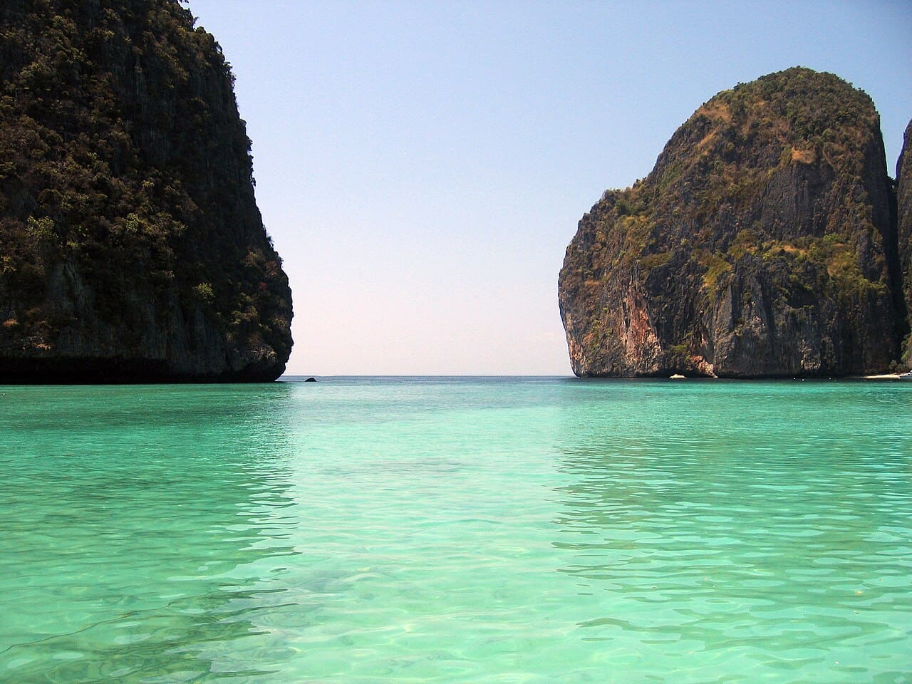 Maya Bay, localizada em Koh Phi Phi, ficou mundialmente famosa após o filme “A Praia”, e desde então tornou-se um dos destinos mais desejados da Tailândia embora o acesso seja controlado para preservar o ecossistema. Cercada por falésias imponentes e águas cristalinas, o local transmite uma sensação de isolamento paradisíaco que encanta visitantes. Após anos de fechamento para recuperação ambiental, a baía reabriu com regras rígidas de preservação, reforçando a importância de equilibrar turismo 