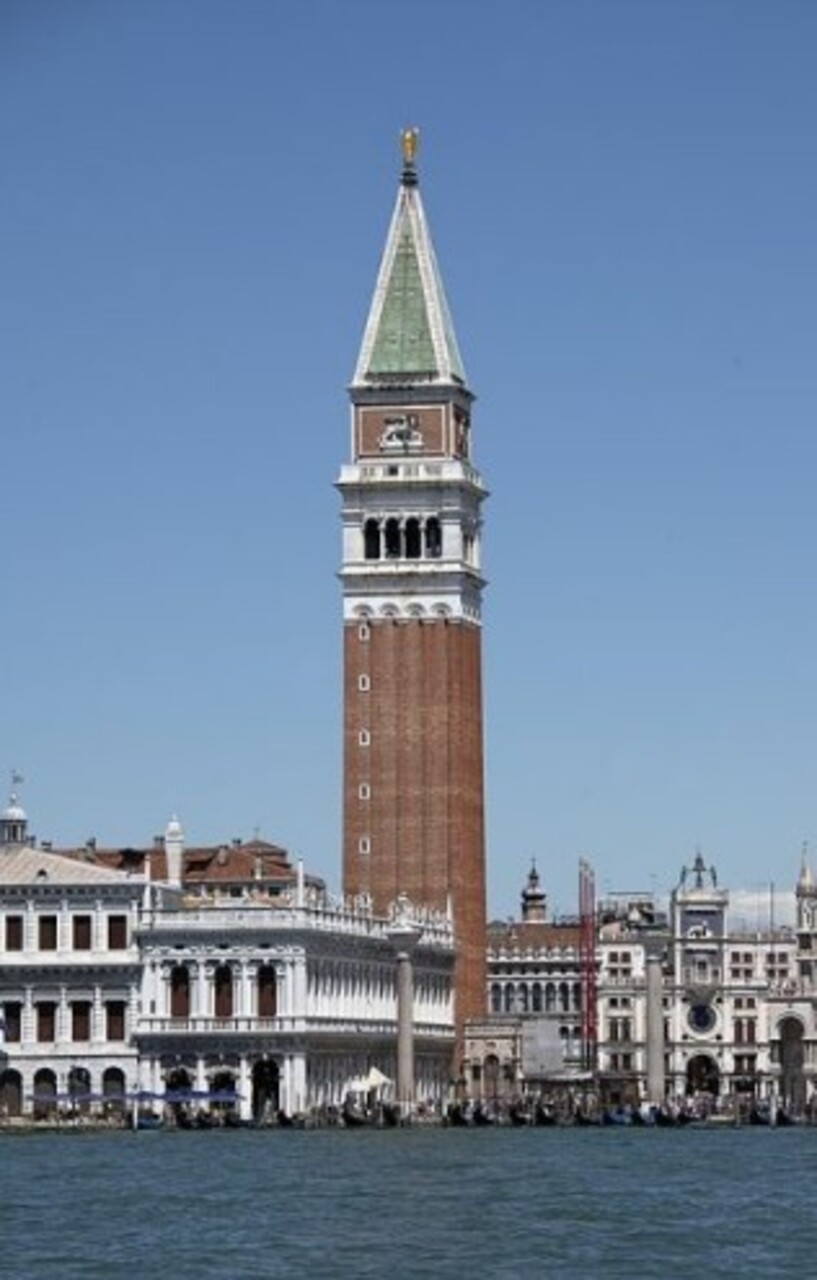 O campanário é a torre mais alta de Veneza, com quase 100 metros de altura, oferecendo vistas panorâmicas da cidade e da lagoa. Reconstruído após desmoronar em 1902, mantém sua função como marco visual e símbolo de resistência. A subida ao topo é uma experiência que conecta o visitante à grandiosidade da paisagem veneziana.

