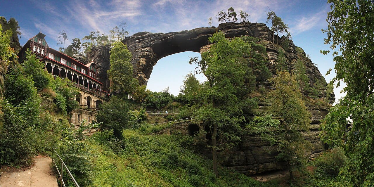 Milhares de turistas visitam Pravcická brána todos os anos, atraídos pela fama de ser o maior arco de arenito da Europa. O local oferece infraestrutura básica, como trilhas sinalizadas e pontos de observação, que permitem contemplar o monumento em diferentes ângulos. A experiência é descrita como inesquecível, especialmente ao pôr do sol, quando a luz realça as cores do arenito.