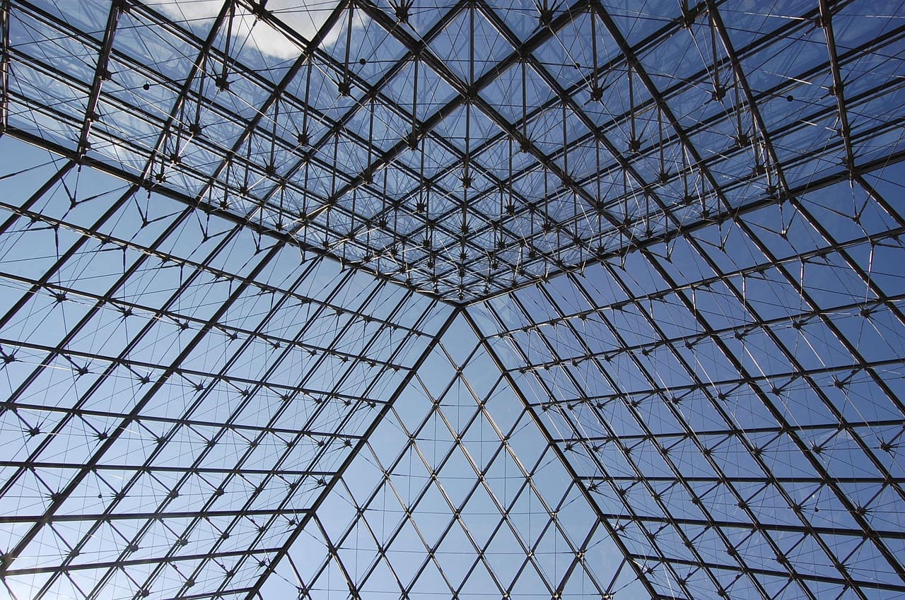 A pirâmide é composta por 673 painéis de vidro, cuidadosamente montados para criar uma superfície transparente e uniforme. Essa precisão técnica foi um desafio para os engenheiros, que precisaram garantir estabilidade e estética ao mesmo tempo. A estrutura metálica sustenta o peso e permite a leveza visual que caracteriza o monumento. Já o uso do vidro simboliza transparência e abertura, valores que dialogam com a ideia de acesso democrático à cultura e marcaram avanço tecnológico na arquitetura
