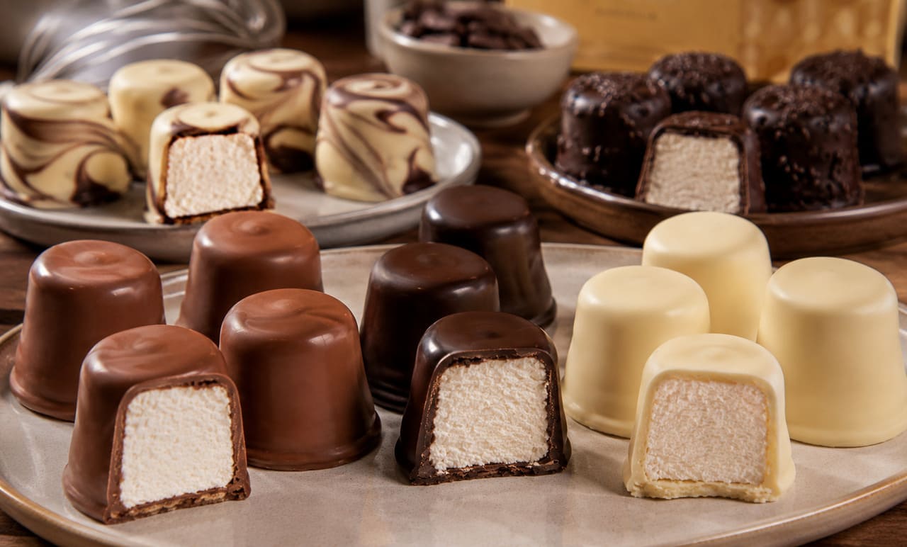 A cobertura pode variar bastante. Embora o chocolate ao leite seja o mais conhecido, também existem versões feitas com chocolate meio amargo, branco ou combinações entre eles. A escolha influencia diretamente o sabor e o equilíbrio da sobremesa. 