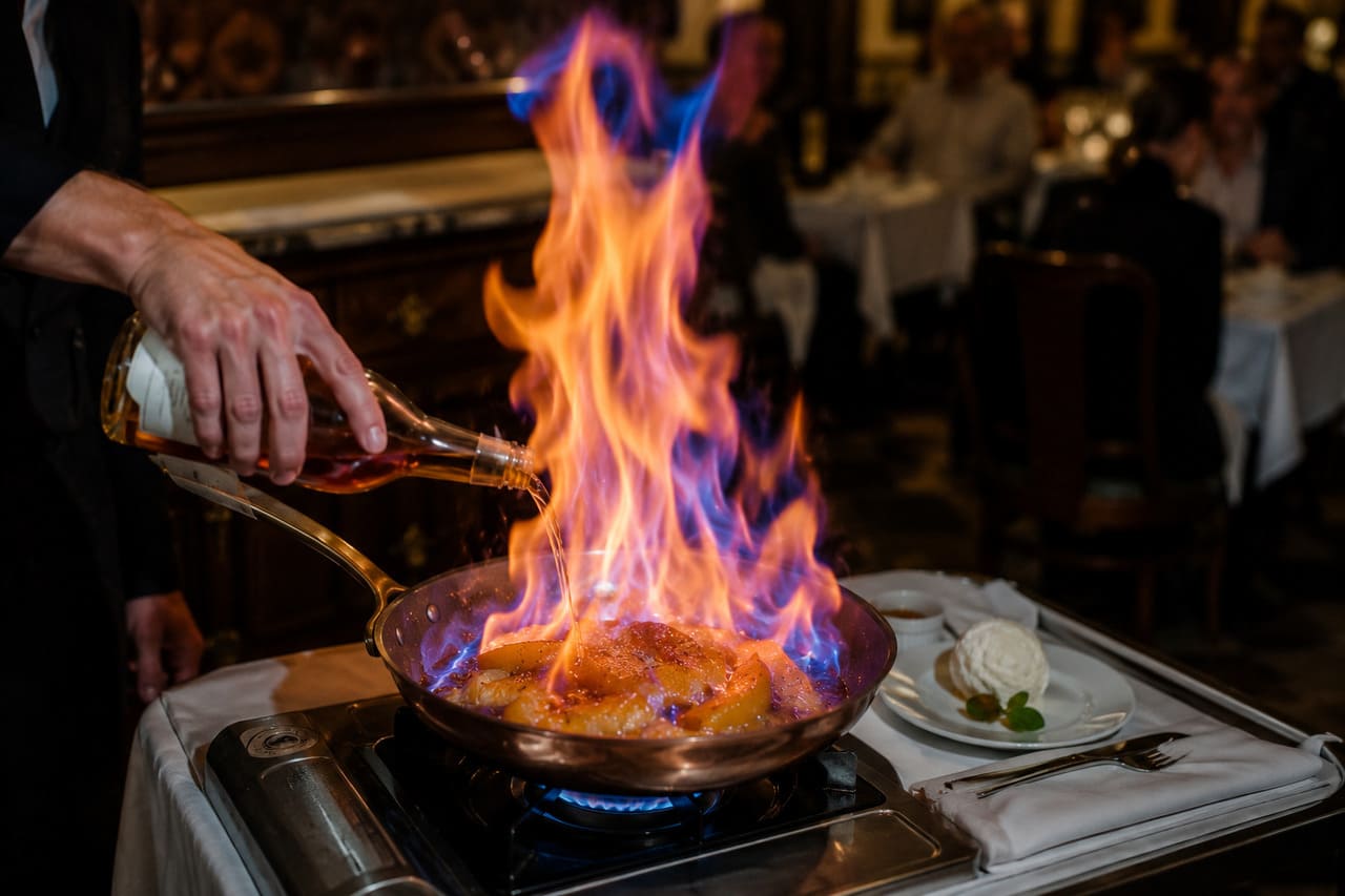 Flambar é uma técnica culinária que transforma o preparo de sobremesas em um verdadeiro espetáculo. Ao entrar em contato com o fogo, bebidas alcoólicas criam chamas que impressionam o público e ajudam a realçar aromas e sabores. Muito além do efeito visual, o flambado confere um toque caramelizado às receitas, tornando a experiência gastronômica ainda mais marcante. -  (crédito: imagem gerada por i.a)