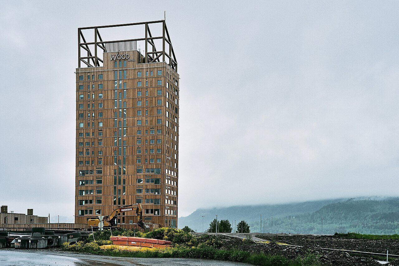 Uma torre erguida na Noruega e finalizada no ano de 2019 se tornou um dos exemplos mais conhecidos do uso de madeira planejada em edifícios altos. O Mjøstårnet, como é chamado o prédio, tem 85,4 metros de altura, 18 pavimentos e utiliza o glulam, também chamado de 'madeira laminada colada', como principal componente de seu sistema estrutural. -  (crédito: Wikimedia Commons/Øyvind Holmstad)
