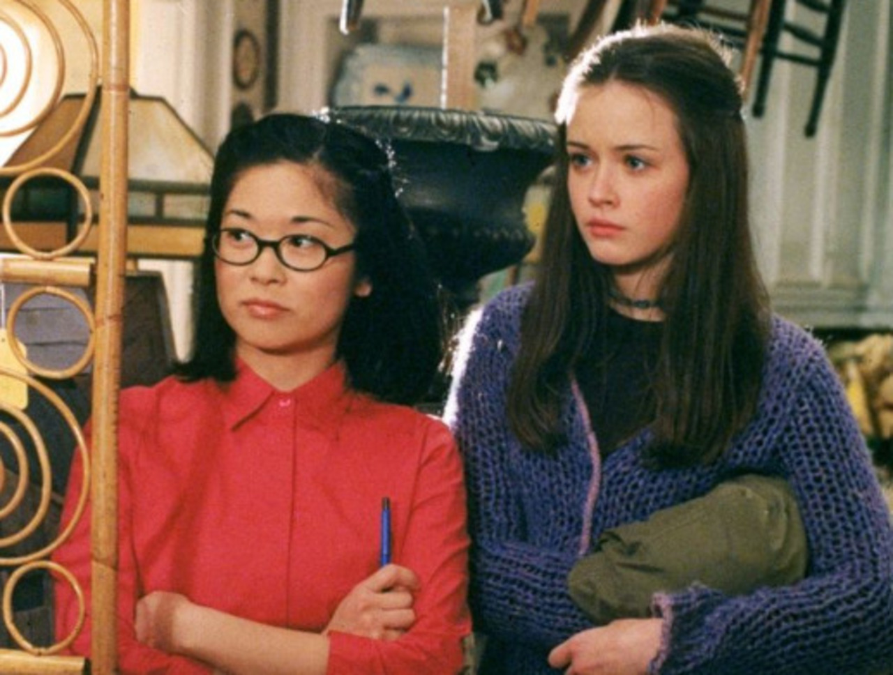 Keiko Agena — Lane, Gilmore Girls - Tinha 27 anos quando começou a interpretar Lane Kim (de vermelho na foto) em Gilmore Girls, em 2000. Sua personagem tinha 16 anos no início da história. Isso significa uma diferença de aproximadamente 11 anos entre atriz e personagem.