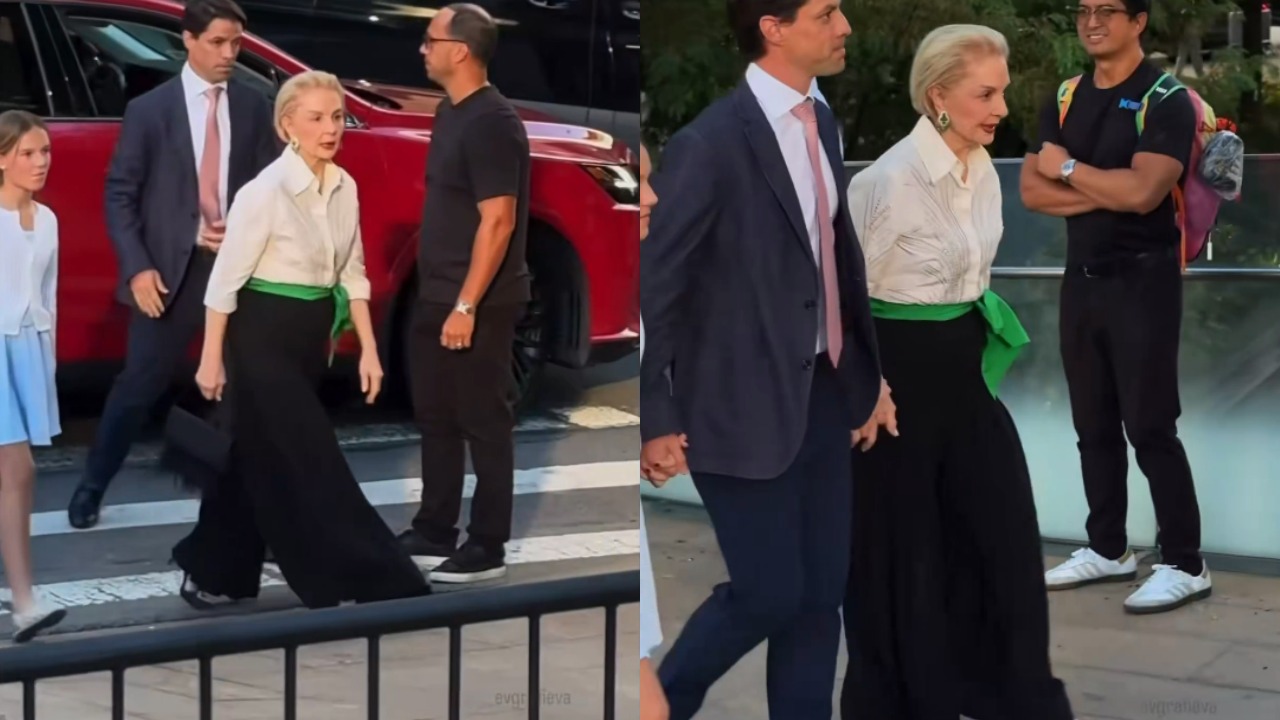 Para a ocasião, Carolina escolheu um look clássico, composto por camisa branca de mangas três quartos, calça preta de modelagem wide leg e uma faixa verde presa à cintura em um grande laço lateral. Ela completou a produção com sapatos de salto alto e brincos grandes.