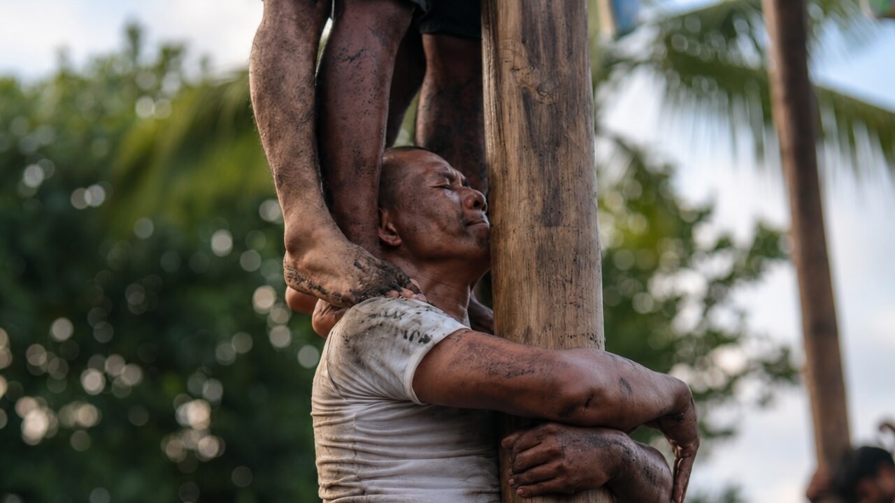 As regras são simples, mas a brincadeira exige força, equilíbrio e estratégia. Truques como subir nos ombros de outro participante costumam ser permitidos. A maioria das tentativas termina com quedas e muita sujeira de graxa. Quem consegue chegar ao topo costuma tocar um sino para anunciar a vitória. 
