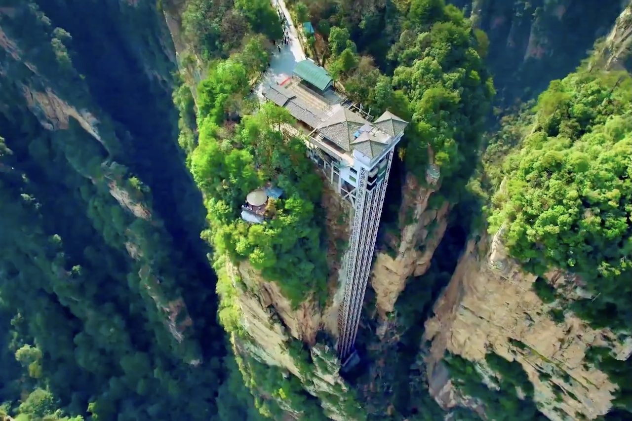 Localizado na província de Hunan, na China, o Elevador Bailong oferece uma das experiências mais impressionantes do turismo mundial ao transportar passageiros pela parede de um penhasco em meio a enormes formações rochosas. -  (crédito: Reprodução/YouTube )
