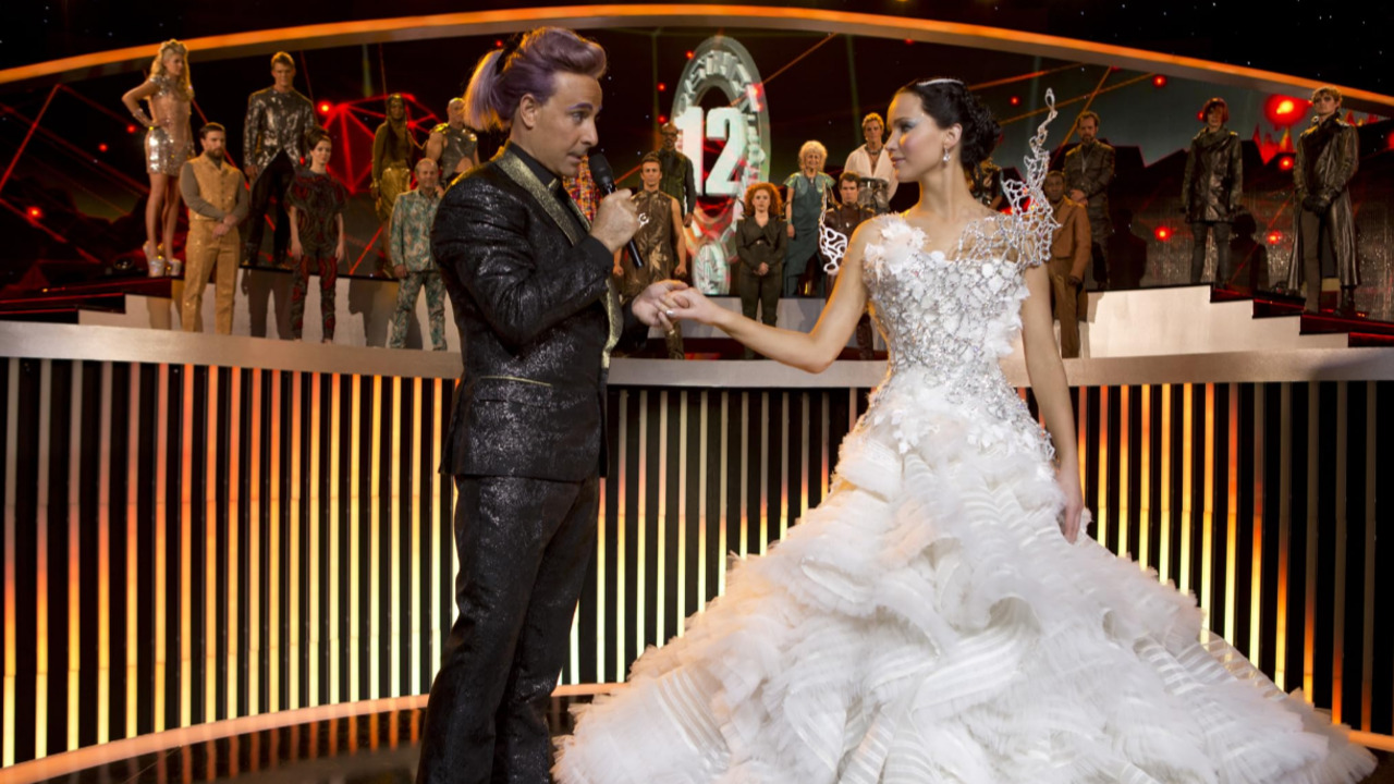No filme, o presidente Snow, interpretado por Donald Sutherland, determina que Katniss use o vestido de noiva durante uma entrevista antes do 75º Jogos Vorazes. Criado pelo estilista Cinna, personagem de Lenny Kravitz, o figurino se transforma no palco em um traje preto com asas, em referência ao Tordo, símbolo associado à protagonista.
