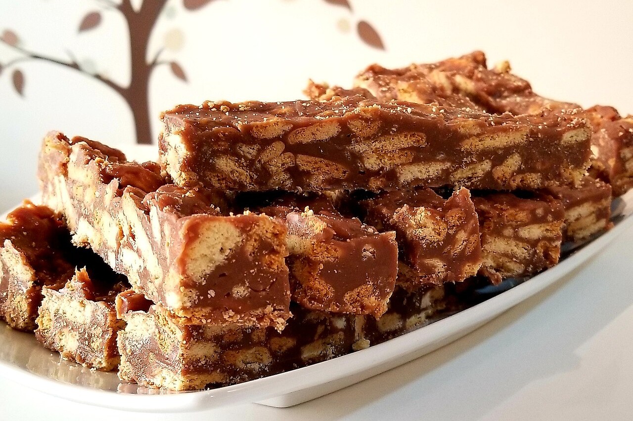 A versão brasileira surgiu da troca da base de chocolate pelo brigadeiro, combinada com pedaços de biscoito maisena. A mudança também alterou o formato do doce, que deixou de ser moldado como um salame e passou a ser cortado em quadradinhos. Com ingredientes comuns na cozinha brasileira, como leite condensado e chocolate em pó, a receita ganhou características próprias.
