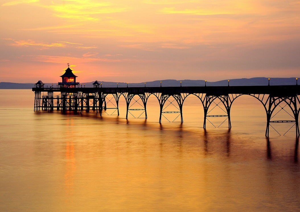 Clevedon Pier — Inglaterra
Inaugurado em 1869, o Clevedon Pier é conhecido pela elegante estrutura metálica que avança sobre o estuário do Severn. Preservado como patrimônio histórico, tornou-se uma das imagens mais características da pequena cidade inglesa.
Card 11 — Progreso Pier — México
