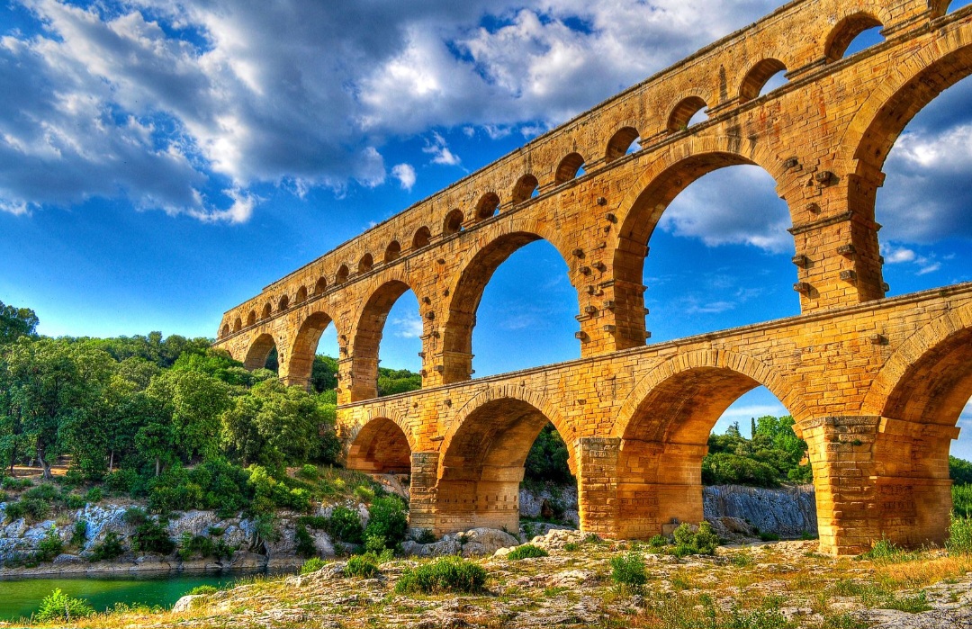 Pont du Gard
Construído pelos romanos no século I, o Pont du Gard é um aqueduto monumental que atravessa o Rio Gardon. Com aproximadamente 49 metros de altura e três níveis de arcos, fazia parte de um sistema que transportava água até a cidade de Nîmes.