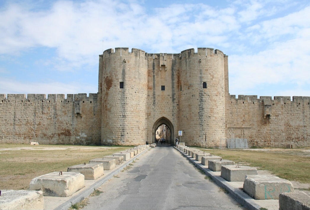 Aigues-Mortes
Fundada no século XIII por iniciativa do rei Luís IX, Aigues-Mortes conserva suas muralhas medievais quase intactas. A cidade fica próxima às paisagens úmidas da Camargue e a extensas salinas, cujas águas podem adquirir tonalidades rosadas.