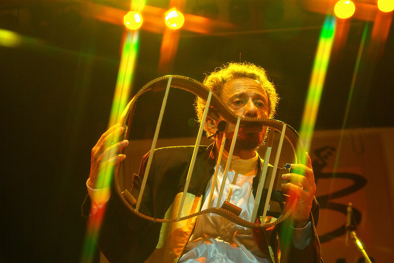 Tom Zé contribuiu para o Tropicalismo com uma abordagem própria, marcada pela irreverência, pela observação do cotidiano e pela desconstrução de estruturas musicais convencionais. Em vez de se limitar a melodias e arranjos tradicionais, passou a explorar ruídos, objetos e combinações sonoras pouco usuais. Essa inquietação aparece em “Todos os Olhos”, de 1973, álbum que ampliou sua pesquisa artística. O trabalho, porém, também contribuiu para distanciá-lo do mercado musical mais comercial, que en